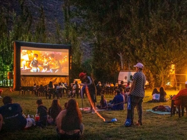 Vecinos de San José de Maipo disfrutando de una función de cine solar al aire libre, impulsada por energía renovable.