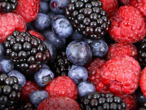 Variedad de frutas y verduras ricas en antioxidantes sobre una mesa.
