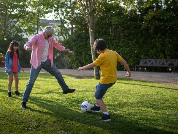 Persona mayor disfrutando una dieta saludable, destacando frutas y verduras como clave para un envejecimiento saludable.