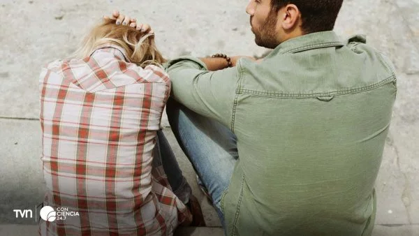 Pareja sentada en silencio en un parque, reflejando distancia emocional.
