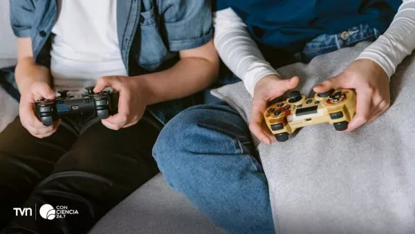 Niño jugando videojuegos en casa con auriculares y joystick.
