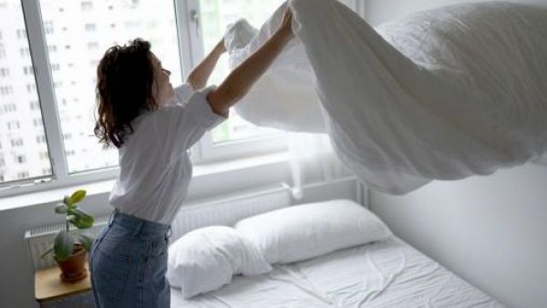 Madre haciendo la cama y un colchón