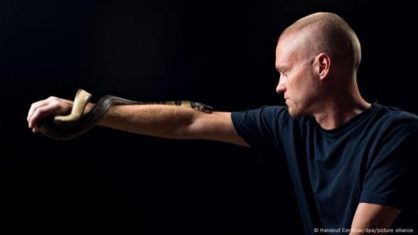 Hombre con serpiente mordiéndole