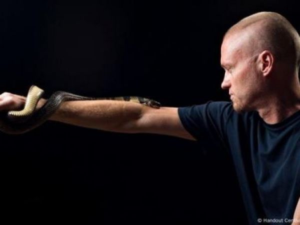 Hombre con serpiente mordiéndole