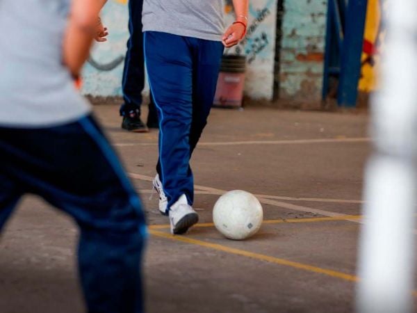 Niños haciendo actividad física en una escuela pública chilena durante una clase de educación física.