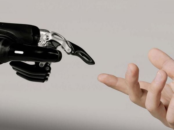 Mano de robot con IA y mano de humano.