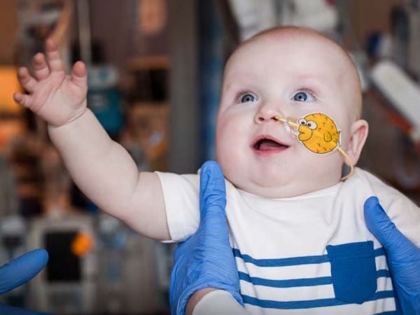 Niño sonriente en casa tras ser el primer paciente tratado con terapia génica CRISPR para una enfermedad metabólica rara.