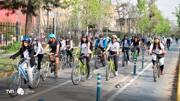 Estudiantes y trabajadores pedaleando por ciclovía en Santiago durante hora punta.