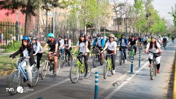 Estudiantes y trabajadores pedaleando por ciclovía en Santiago durante hora punta.