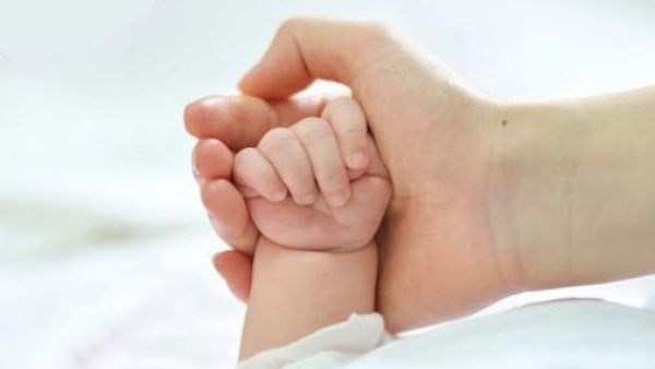 Mano de un bebé y persona adulta