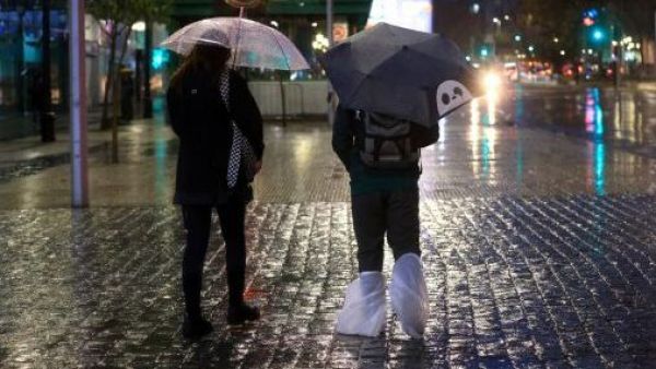 Personas bajo la lluvia en Santiago