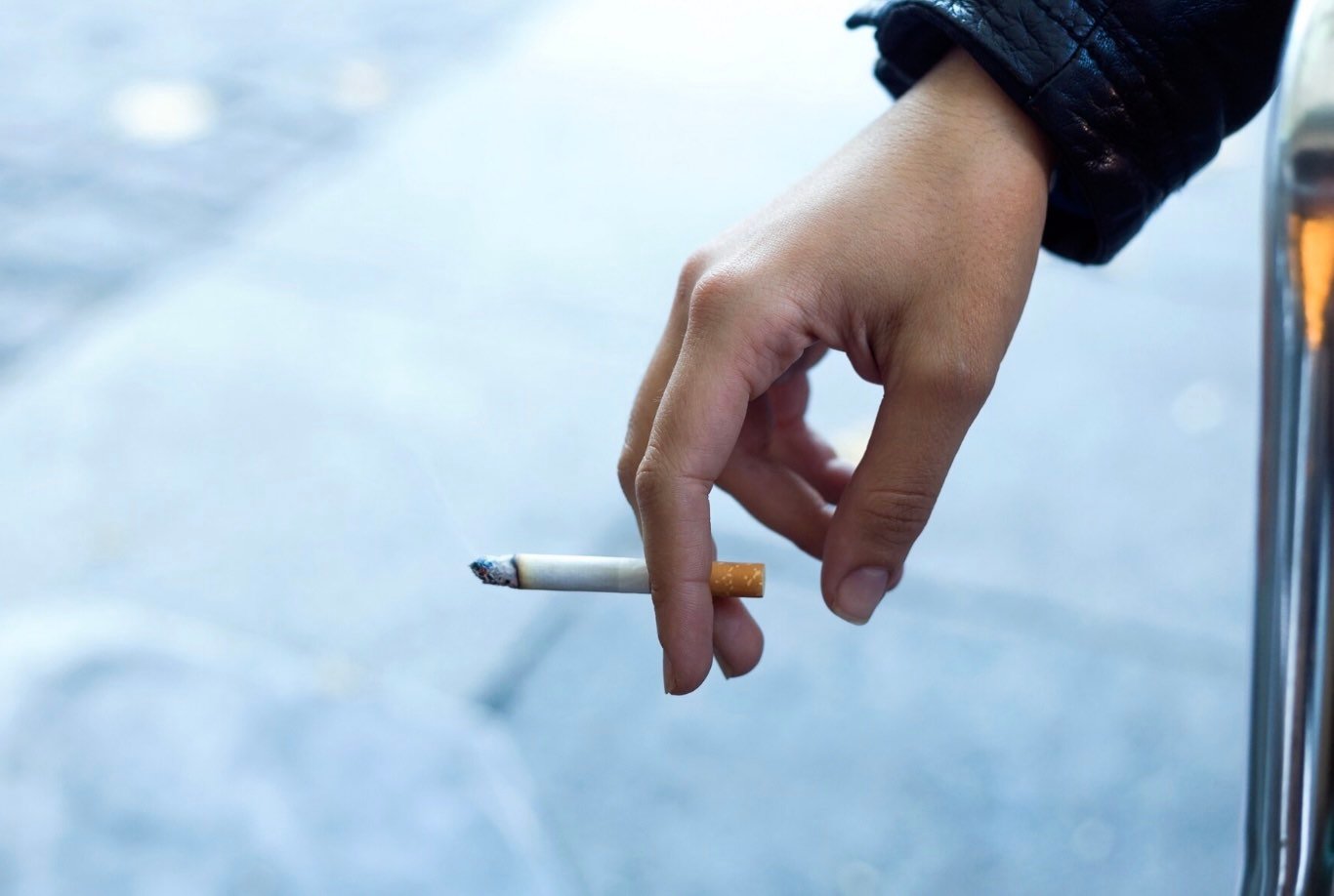 Mano con un cigarro. Persona fumando