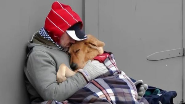Hombre abrazando a su perro