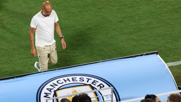 Pep Guardiola dirigiéndose a la banca del Manchester City