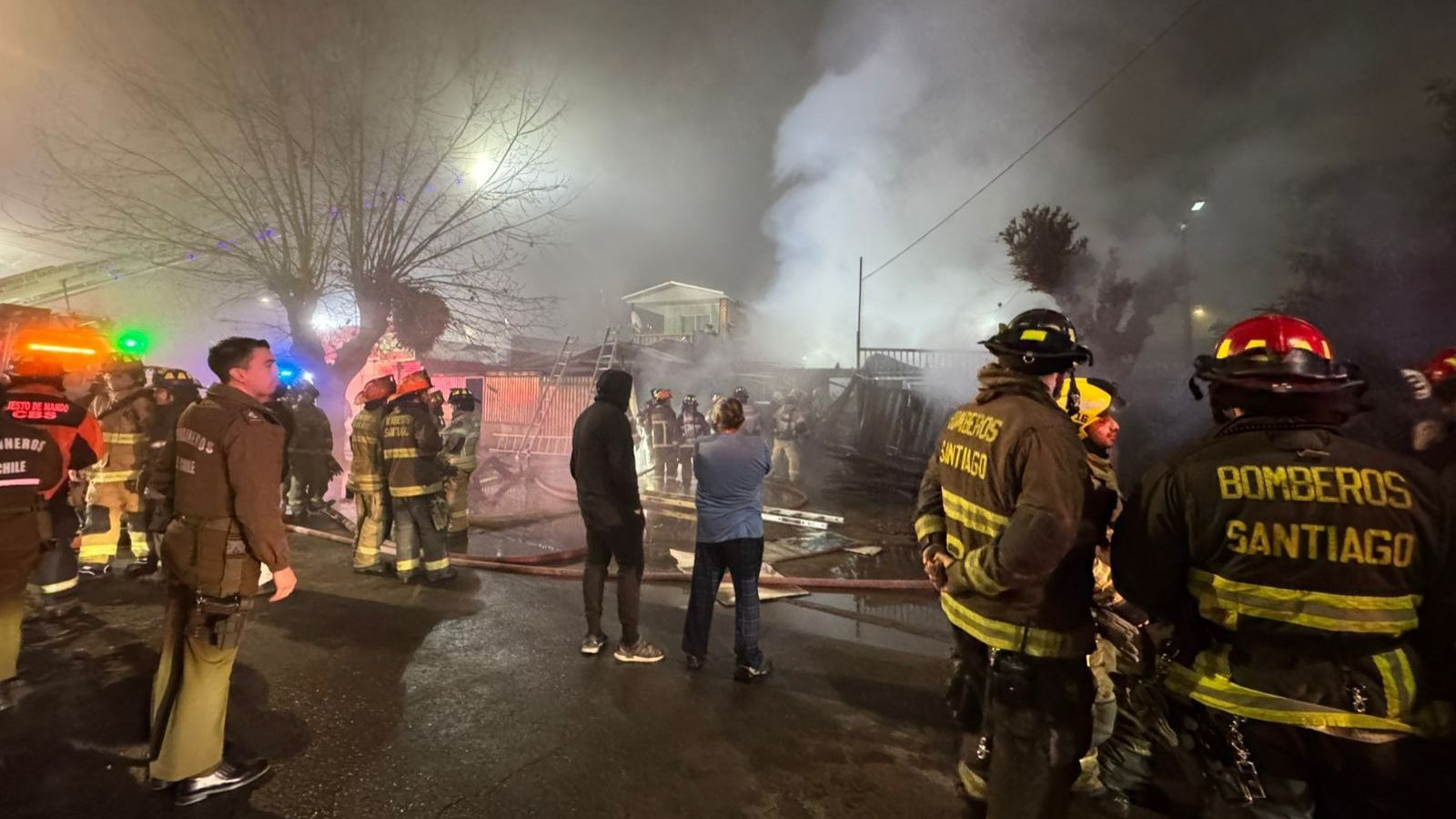 Voluntarios de Bomberos junto a Carabineros en el lugar del incendio.