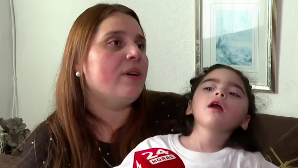 Valeska, madre de Trinidad, sentada con ella en brazos hablando frente a cámara