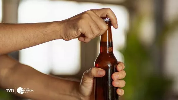 Botella de vidrio con tapa de plástico que genera microplásticos.
