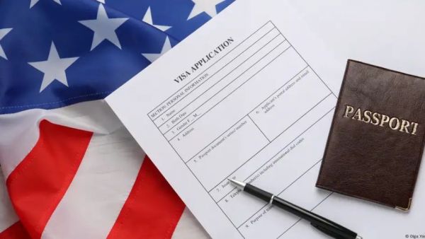 Bandera de EE.UU. y documento de visa junto a un lápiz.