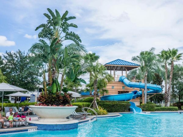 Imagen referencial de un tobogán azul en medio de una piscina