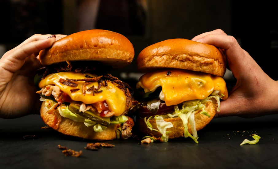 dos hamburguesas con queso y salsas