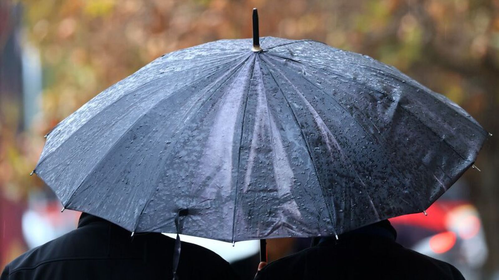 Personas bajo la lluvia con paraguas. Lluvia en Santiago.