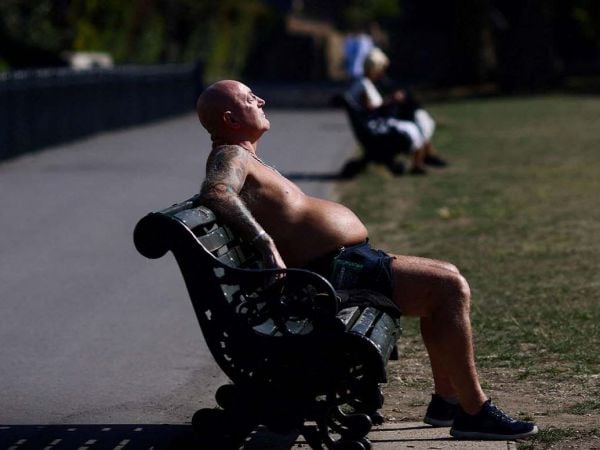 Personas refugiándose del calor bajo la sombra durante una ola de calor extremo.