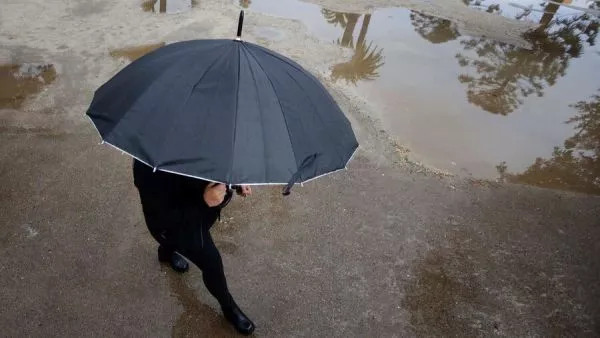 Persona bajo la lluvia con paraguas.