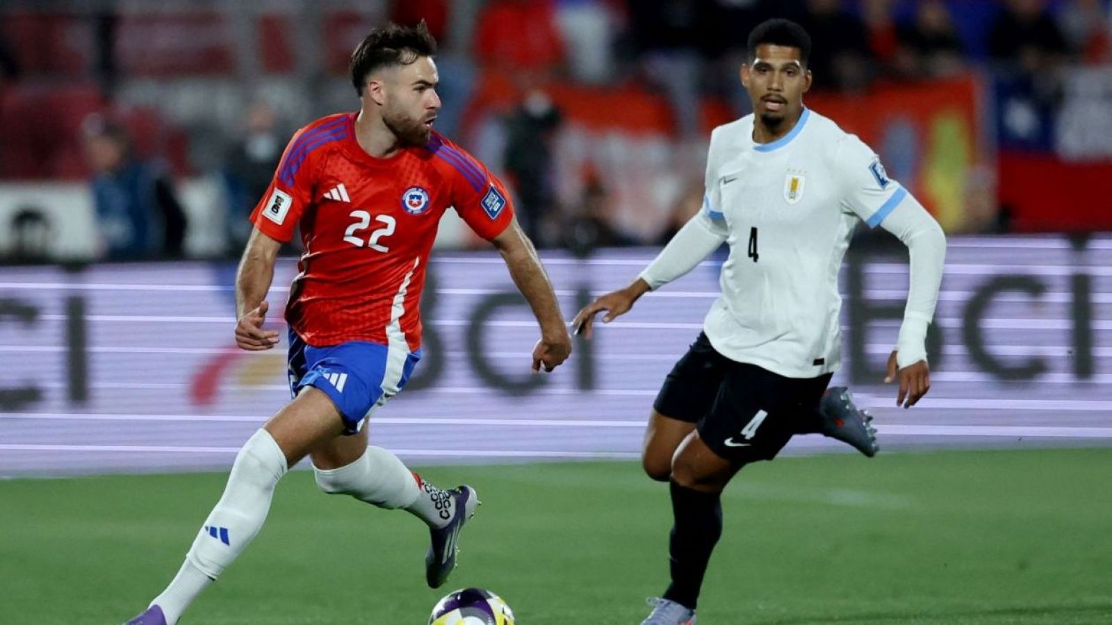 Ben Brereton y Ronald Araújo disputando un balón en el Estadio Nacional durante el partido entre Chile y Uruguay en las Eliminatorias Sudamericanas
