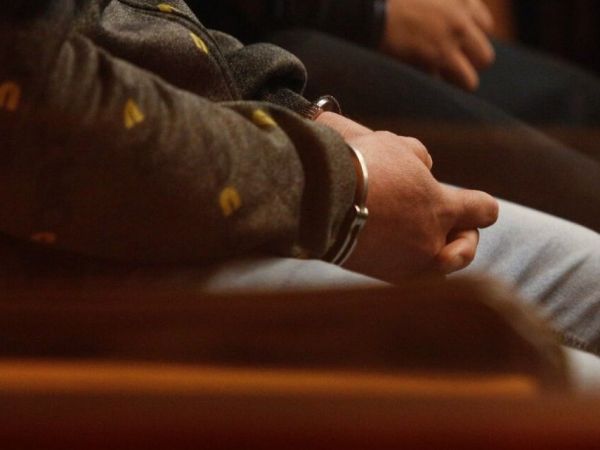 Manos de hombre con esposas tras ser detenido.