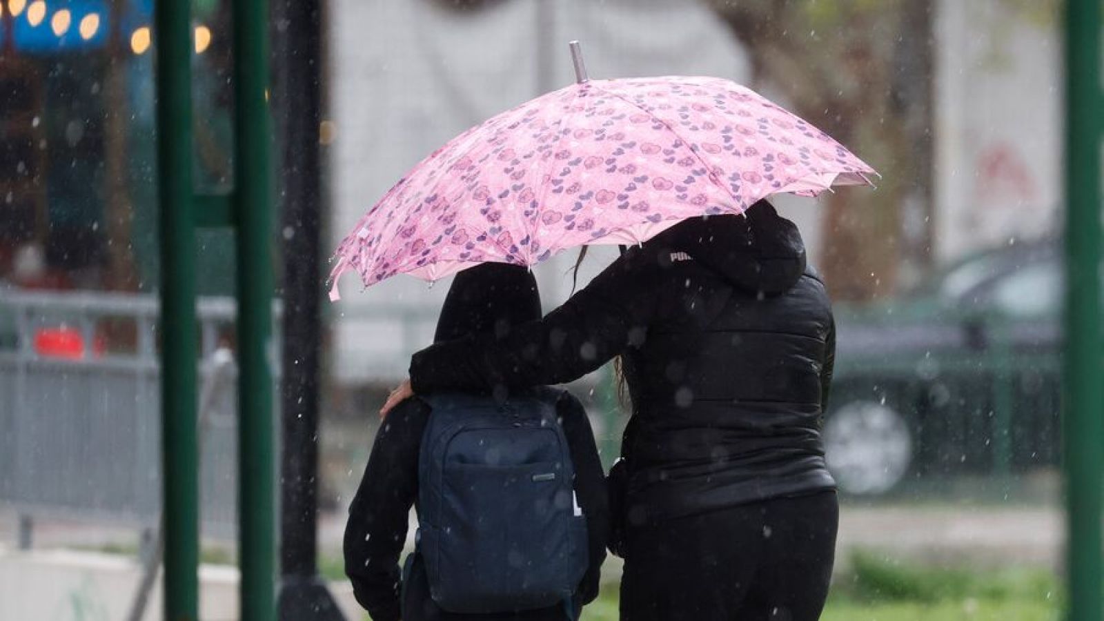 Personas bajo la lluvia con paraguas. Santiago
