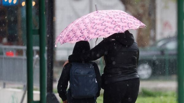 Personas bajo la lluvia con paraguas. Santiago