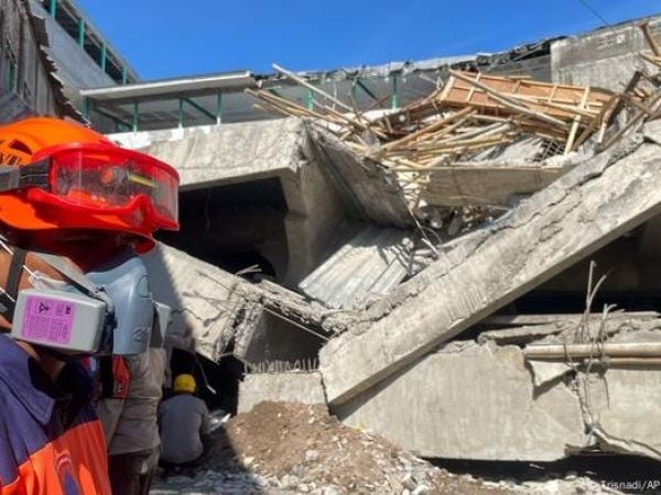 Rescatista en colegio que se derrumbó en Indonesia.