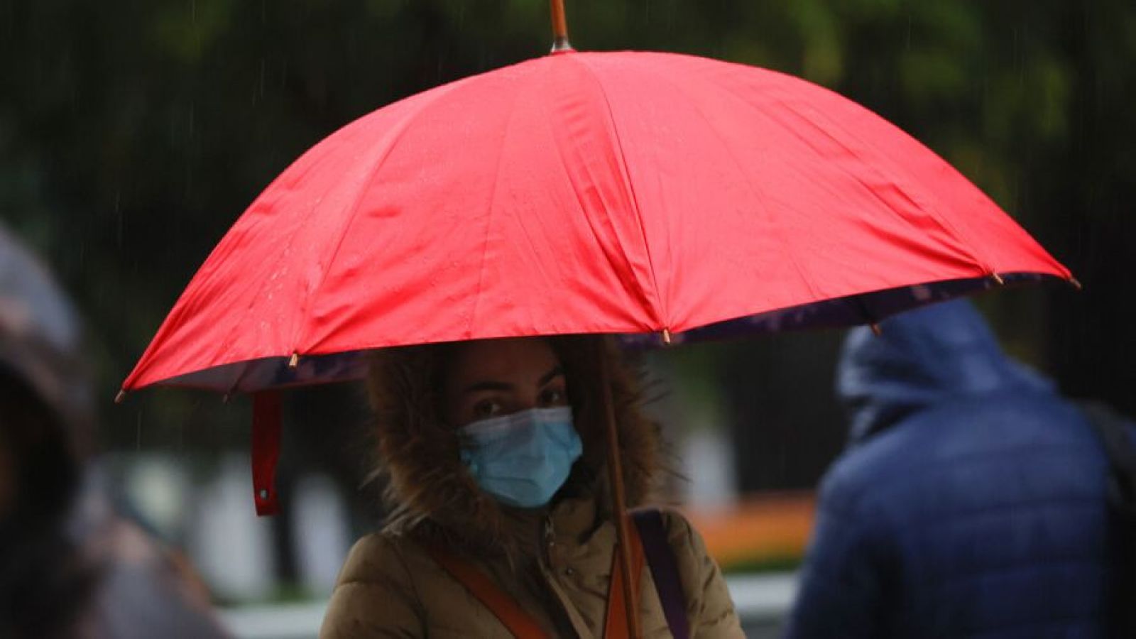 Persona con paraguas bajo la lluvia en Santiago.