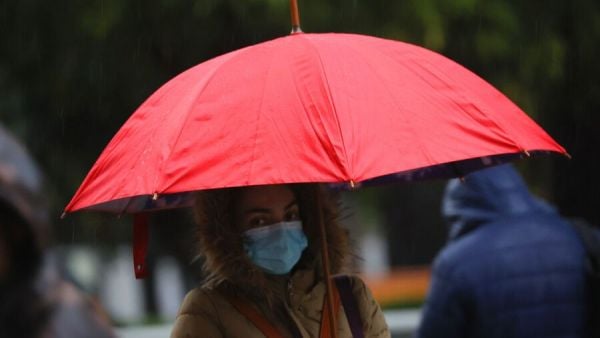 Persona con paraguas bajo la lluvia en Santiago.