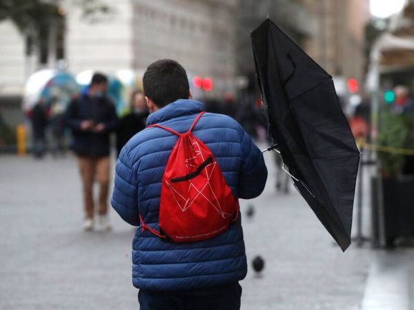 Persona caminado con paraguas y viento