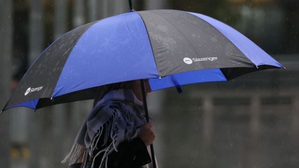 Persona con paraguas bajo la lluvia en Santiago.