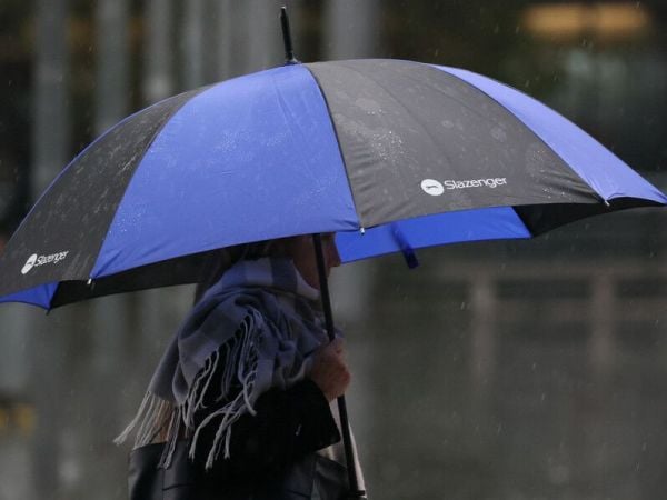 Persona con paraguas bajo la lluvia en Santiago.