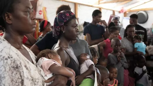 Haitianos/personas desplazadas recibiendo comida en un refugio en Puerto Príncipe (Haití)