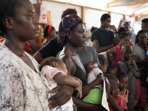 Haitianos/personas desplazadas recibiendo comida en un refugio en Puerto Príncipe (Haití)