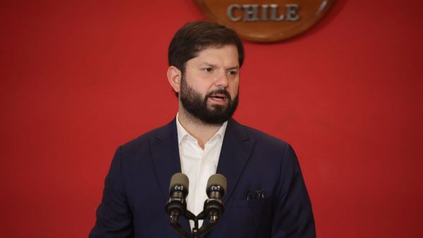 Presidente Gabriel Boric on fondo rojo en sus espaldas.