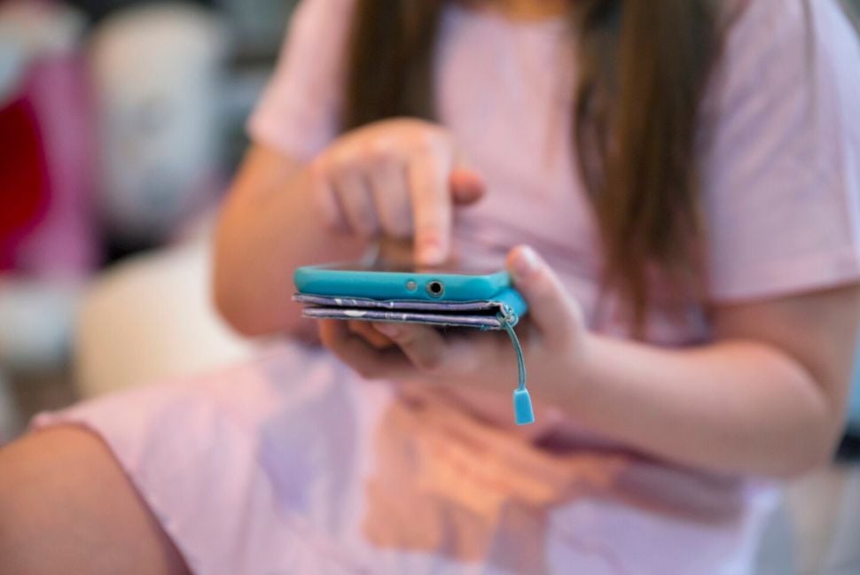 Adolescente con celular en mano