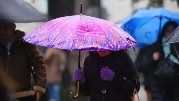 Persona bajo la lluvia en paraguas