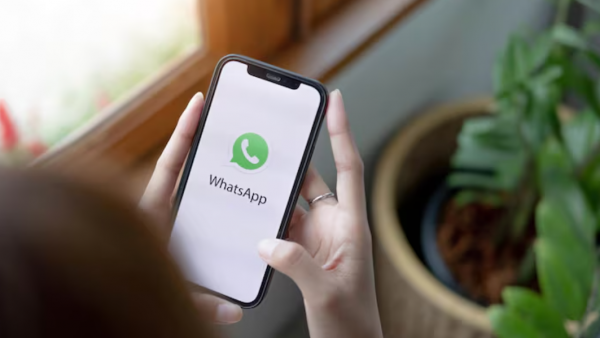 Manos tomando un celular con la aplicación de WhatsApp.