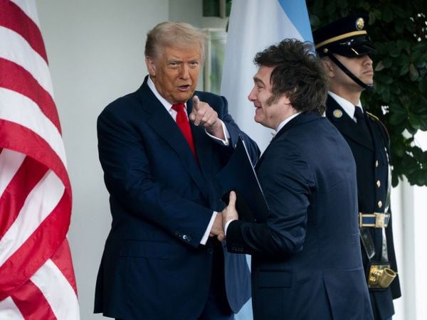 Milei y Trump dándose la mano.