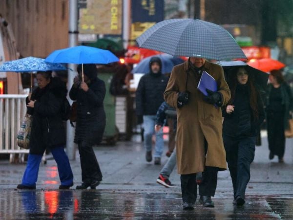 Personas bajo la lluvia en paraguas.