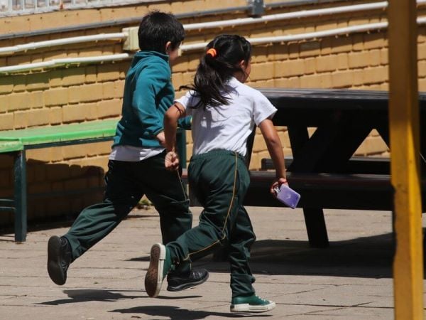 Niños corriendo en el patio de un colegio