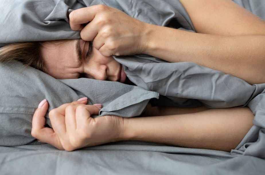 Mujer intentando dormir en su cama