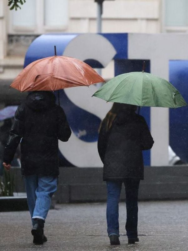 Personas bajo la lluvia en Santiago