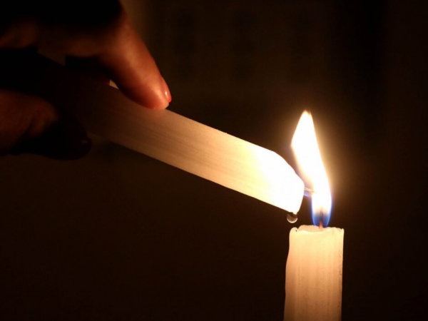 Mano encendiendo una vela.