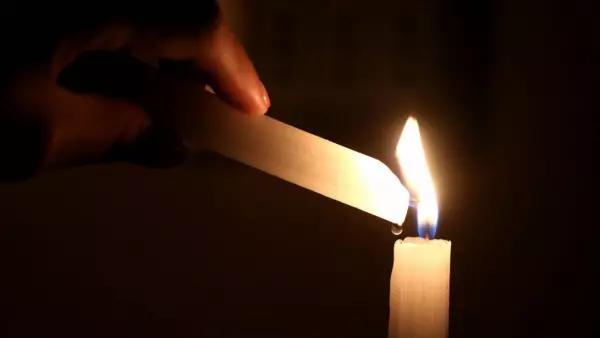 Mano encendiendo una vela.